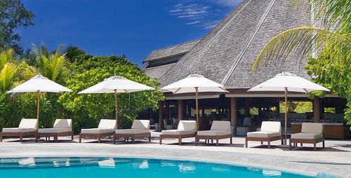 Holiday resort with pool and luxury white parasols and sun beds with upholstery fabrics