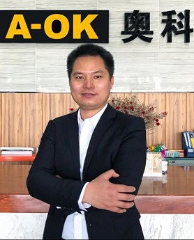 Liu Shengli CEO of Guangdong A-OK Technology Grand Development with A-OK logo is giving an interview